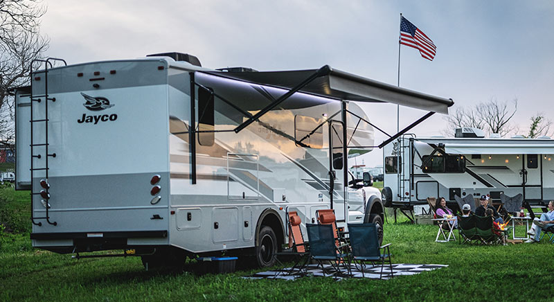 Photo of Jayco greyhawk XL at campground with American flag in the background.