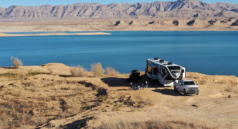 Photo of Grand Design Momentum toy hauler parked near a lake.