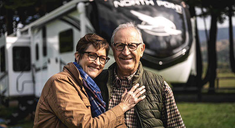 Photo of couple standing in front of their Jayco North Point fifth wheel.